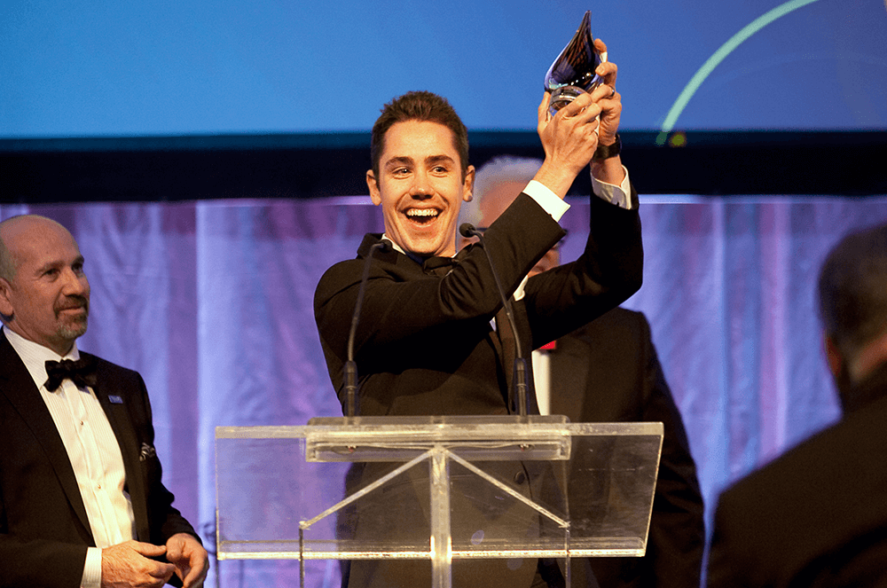 Man holding up award onstage