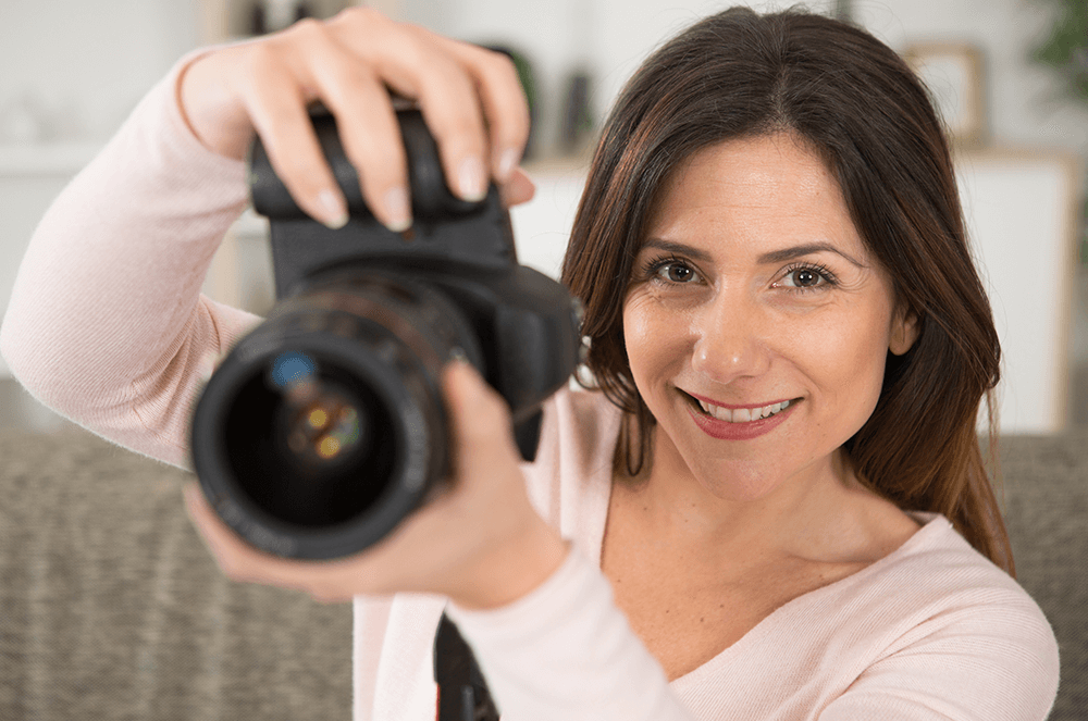 Woman holding up camera to take photo