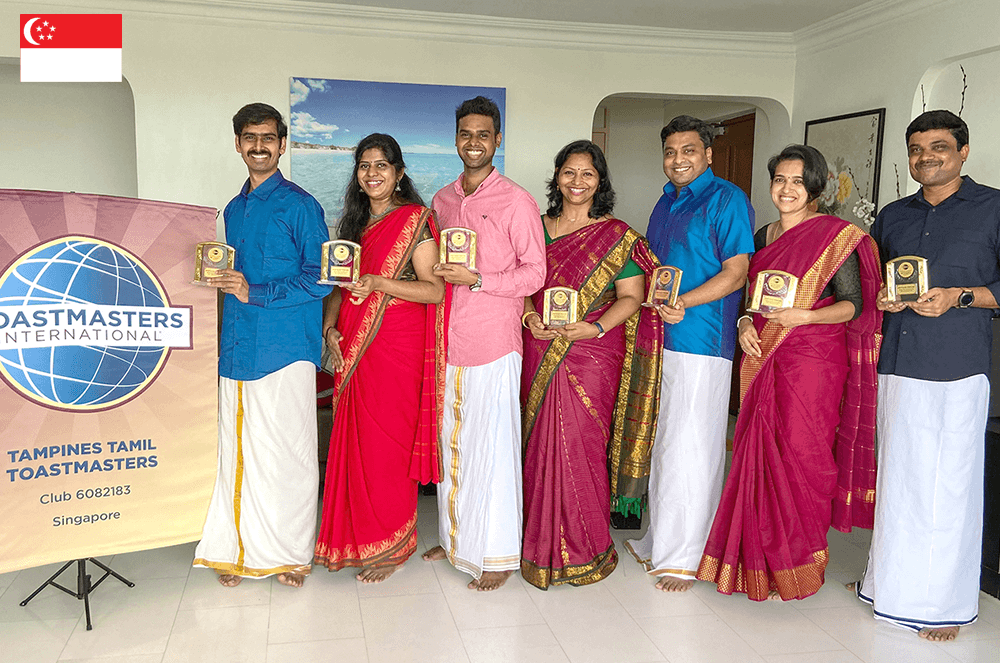 Seven people posing next to banner