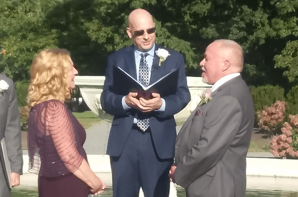 Man officiating outdoor wedding ceremony