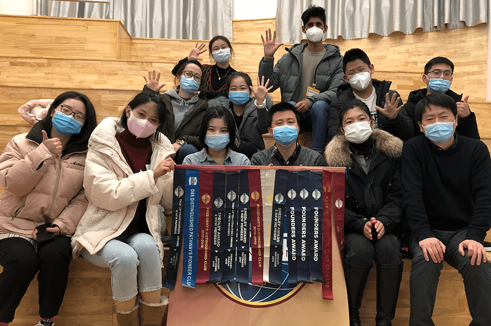 Group of people wearing masks and holding banner