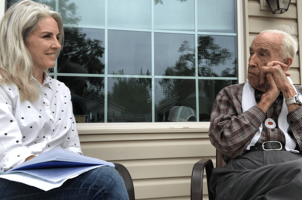 Woman interviewing man on front porch