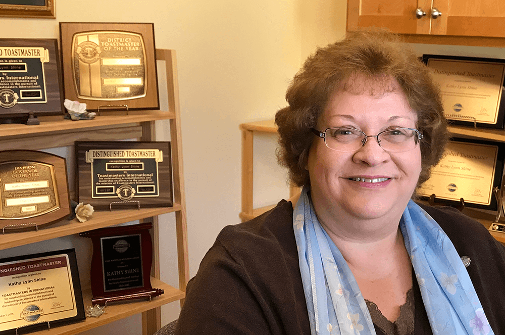 Woman smiling with plaques in background