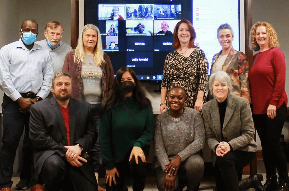 Group posing in front of screen